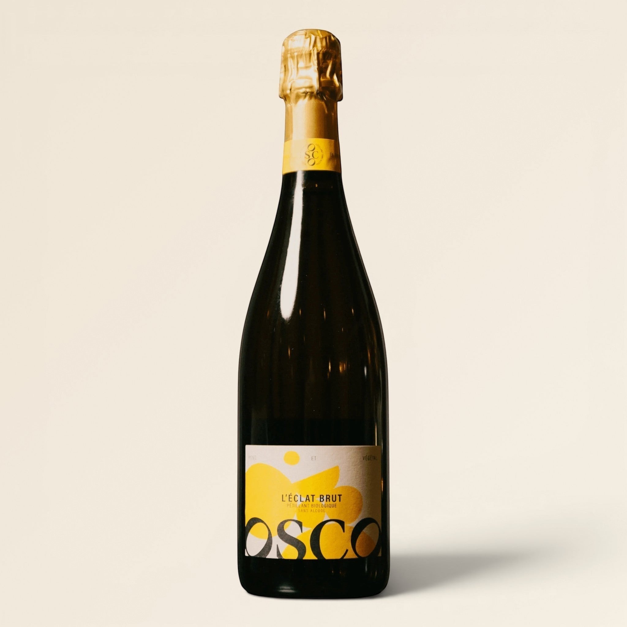 OSCO L'Éclat Brut non-alcoholic sparkling drink in a dark glass bottle with a yellow label and gold foil neck.