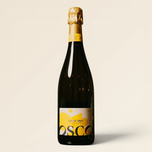 OSCO L'Éclat Brut non-alcoholic sparkling drink in a dark glass bottle with a yellow label and gold foil neck.