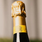 OSCO L'Éclat Brut sparkling drink close-up on gold foil neck.